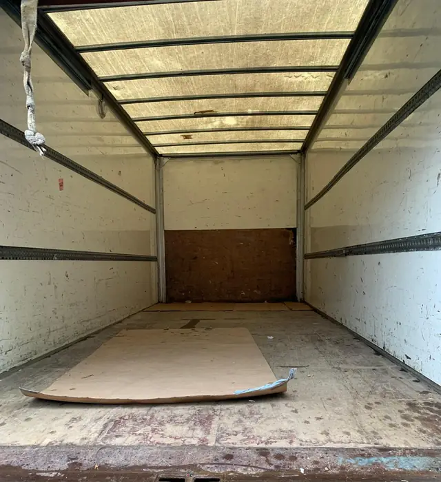 Inside of an empty box lorry with cardboard laid on the floor, swept and ready to load